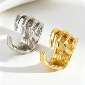 Close-up detail of punk style skeletal hand ear cuffs in gold and silver colors