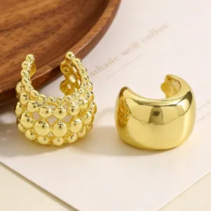 Macro view of elegant gold-plated ear cuffs featuring beaded and smooth polished designs