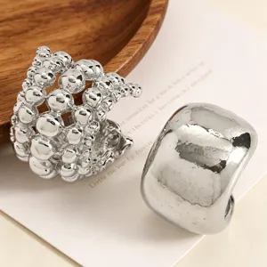 Close-up of silver beaded and smooth wide band ear cuffs for non-pierced ears.
