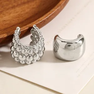 Detailed close-up showing silver ear cuffs with beaded texture and polished finish