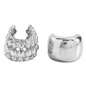 Close-up of silver-tone ear cuffs featuring beaded texture and smooth polished finish