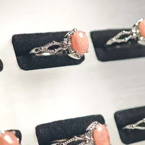 Macro detail of natural rhodochrosite oval stone on an intricate silver plated ring