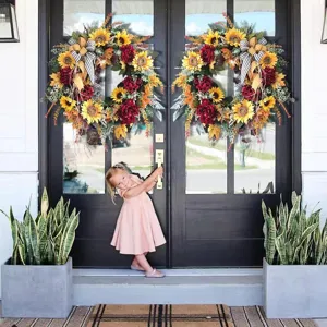 Sunflower and red peony wreaths in rustic country style hanging on black double doors