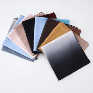 Collection of multi-colored and gradient chiffon scarves fanned out on white background
