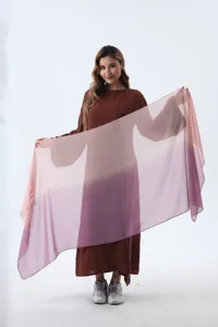 Model holding a pink and purple gradient chiffon scarf in front of a brown dress