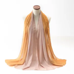 Detail view of lightweight gradient chiffon scarf in soft orange and pink tones