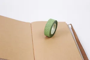 Green glitter washi tape detail shot, sparkling adhesive paper tape for journaling and DIY crafts.