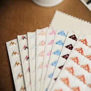 Floral photo corner stickers for scrapbooking and DIY picture frames. Detail view of multi-color patterns.