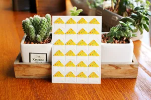 Close-up detail of yellow polka dot paper photo corner stickers for DIY scrapbook albums.