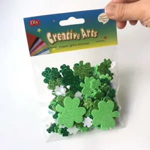 Close-up view of green glitter foam clover stickers in a retail bag, detailed craft supply.