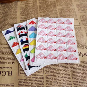 Close-up details of colorful DIY photo corner stickers featuring flags, floral patterns and text.