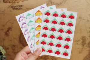 Close-up detail view of cute cartoon fruit photo corner stickers, perfect for DIY scrapbooking.