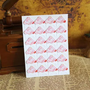 DIY photo corner stickers with pink floral wing pattern, self-adhesive mounts for album craft.