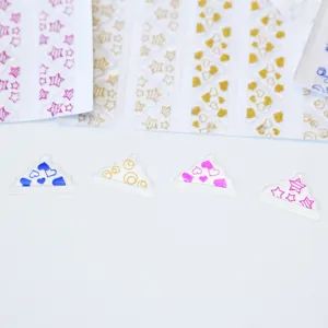 Vue détaillée d'autocollant transparent doré avec cœurs, étoiles et pois brillants.