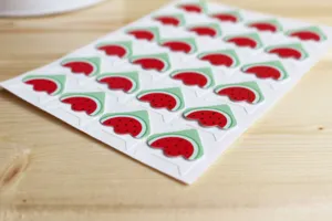 Detail shot of watermelon shaped photo corner stickers, cute paper DIY scrapbooking supplies.