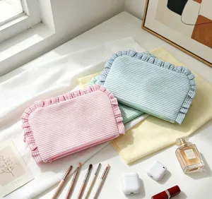 Striped ruffle cosmetic bag, portable zipper makeup pouch for travel and daily storage.