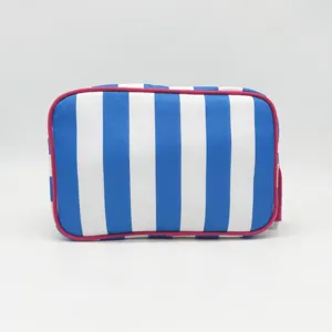 Detailed view of the blue and white striped waterproof cosmetic pouch with pink trim and tassel.