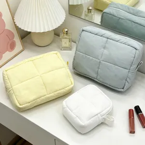 Detailaufnahme von gesteppten Nylon-Kosmetiktaschen in Pastellfarben, Make-up-Organizer.