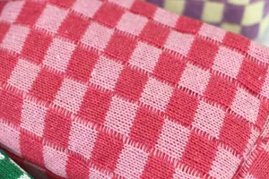Trousse de maquillage tricotée à carreaux rose détail texture gros plan pochette mignonne