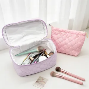 Detailed view of quilted cosmetic bags, portable makeup storage organizer with soft texture.