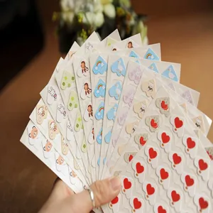 Close-up detail of colorful cartoon photo corner stickers for DIY scrapbook album crafting.