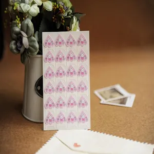 Detailed close-up of paper corner stickers with cute cartoon rabbit design for DIY photo albums.