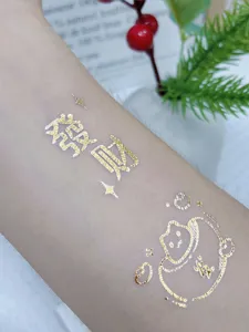 Gold foil temporary tattoo sticker with lucky Chinese character and cute animal design.
