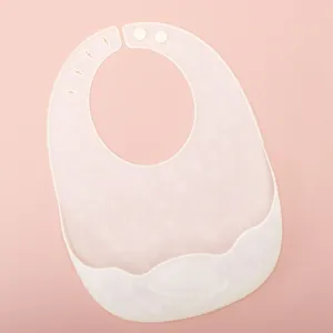 Babero de silicona suave para bebé con recogedor y botones ajustables para una alimentación fácil.