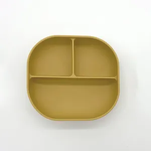 Vista dettagliata del piatto per neonati in silicone giallo senape con tre scomparti pratici.