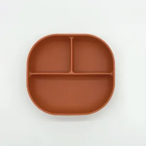 Silicone baby suction plate with three compartments in terracotta color for infants feeding.