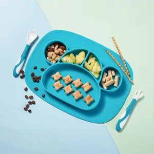 Vista dettagliata del piatto pappa in silicone blu con scomparti divisi e posate per bambini.