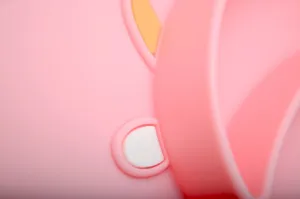Primo piano di piatto pappa in silicone rosa per neonati con simpatiche orecchie.