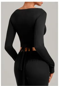 Back detail view of black long sleeve wrap yoga top with stylish tie back design for women.