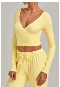 Detailed view of the yellow v-neck wrap-around long sleeve yoga crop top and drawstring pants.