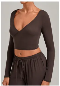Close-up detail of the dark brown wrap-around long sleeve yoga top showing V-neck design.