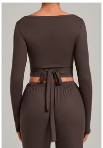 Back detail of dark brown wrap long sleeve yoga top and matching athletic trousers set.