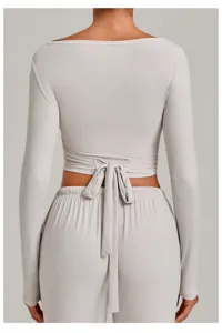 Detailed back view of light grey long sleeve wrap yoga top featuring a stylish back tie.