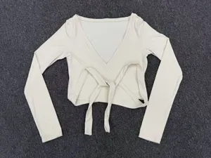 Detailed view of the solid color wrap yoga top with long sleeves and front self-ties.