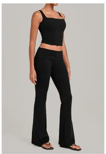 Close-up detail of black yoga set, featuring ribbed crop top and fold-over flare pants.
