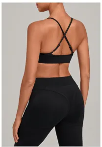 Detailed view of women's black sports bra with cross back straps and activewear leggings.