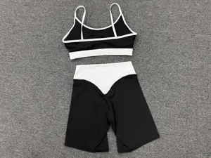 Schwarz-weißes Yoga-Set mit Doppelträger-Sport-BH und hochgeschnittenen Fitness-Shorts.