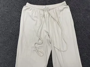 Casual wide-leg yoga pants detail shot, elastic drawstring waist, off-white color.