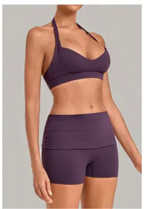 Detail view of women purple halter sports bra and high waist yoga shorts for fitness.