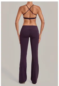 Paarse yoga set voor dames met een kruisband sportbeha en een uitlopende omslagbroek.