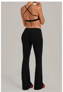 Zwarte sportbeha met kruisrug en uitlopende yogabroek met omgeslagen taille voor fitness.