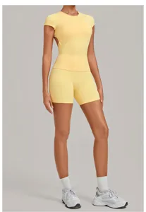 Yellow open back yoga outfit athletic short sleeve top and tight fitness shorts set.
