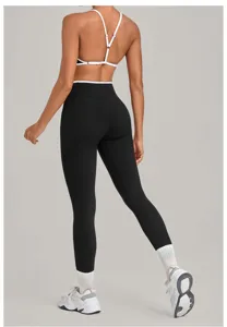 Women strappy sports bra and high waist black yoga leggings set for fitness and running workout.