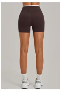 Detail view of dark brown yoga shorts with contrasting white waistband trim for fitness.