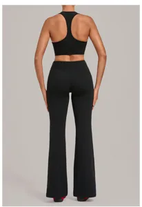 Ensemble de yoga noir deux pièces, haut court de fitness respirant et pantalon évasé.