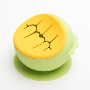 Silicone baby snack cup detail view showing flexible yellow lid and suction base features